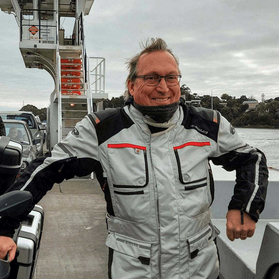 Lance in his riding jacket, smiling on the deck of a car ferry