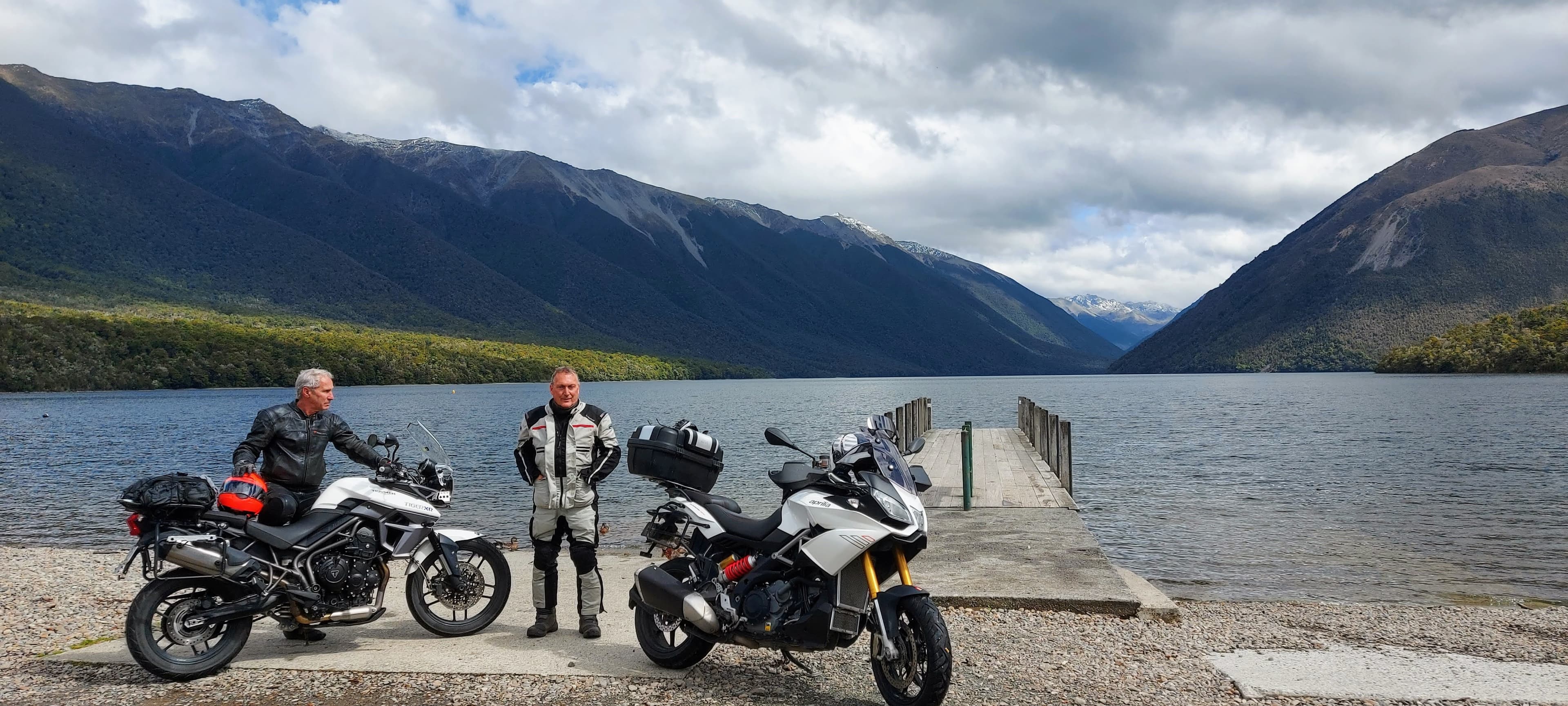 Motorcycle tour guide with two bikes in front of a lake